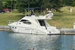 Pilot House Yacht Photos Pics 2003 Sealine F42/5 yacht docked by a grassy shoreline.