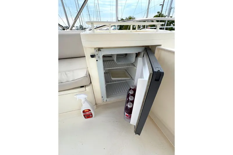 Pilot House Yacht Photos Pics Open mini fridge on 2003 Sealine F42/5 yacht with drinks and cleaning spray nearby.