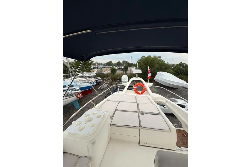 Pilot House Yacht Photos Pics 2003 Sealine F42/5 yacht deck with seating and canopy, docked in a marina.