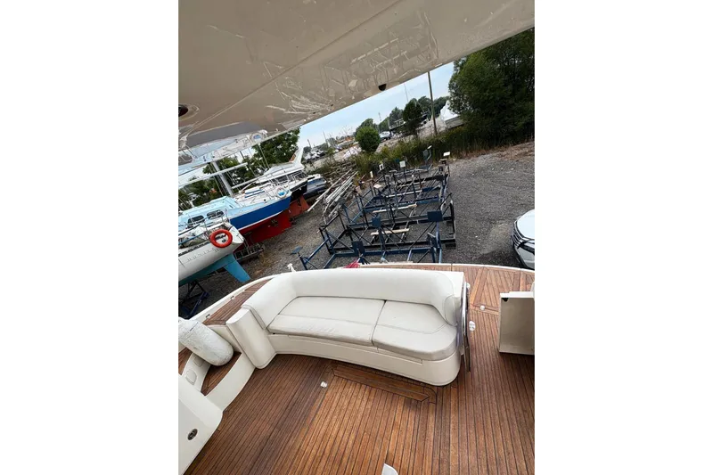 Pilot House Yacht Photos Pics 2003 Sealine F42/5 yacht deck with white seating and wooden flooring.