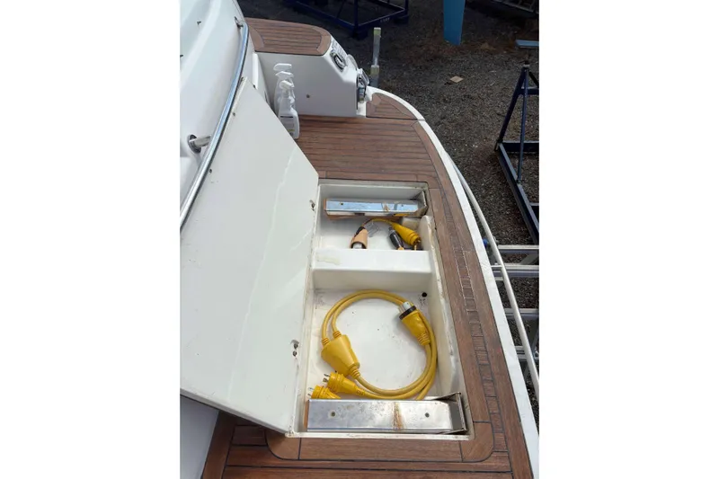 Pilot House Yacht Photos Pics 2003 Sealine F42/5 yacht deck with open storage compartment and yellow power cable.