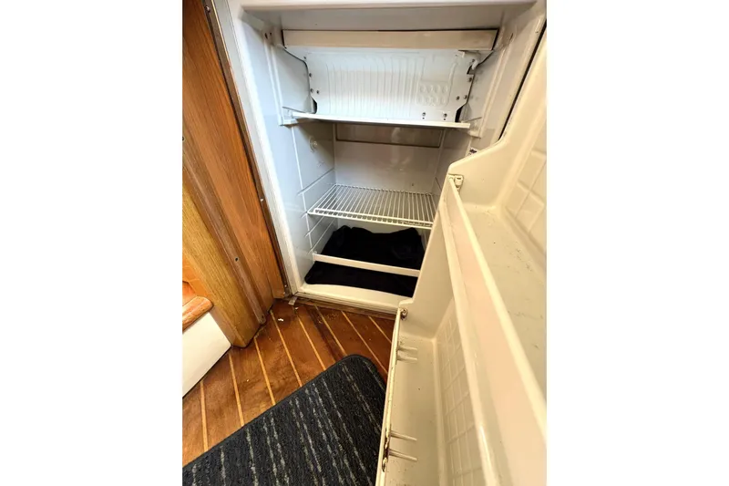 Pilot House Yacht Photos Pics Open refrigerator inside 2003 Sealine F42/5 yacht, wooden flooring visible.