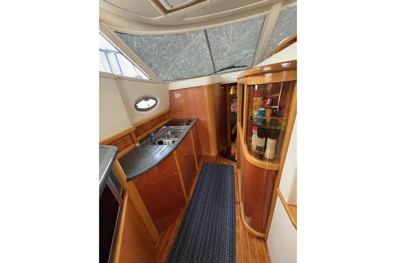 Pilot House Yacht Photos Pics Interior of 2003 Sealine F42/5 yacht with wooden cabinetry and modern kitchen amenities.