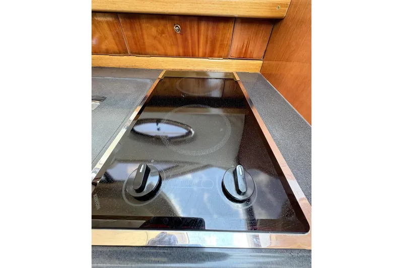 Pilot House Yacht Photos Pics Stovetop in 2003 Sealine F42/5 yacht kitchen with wooden cabinetry.