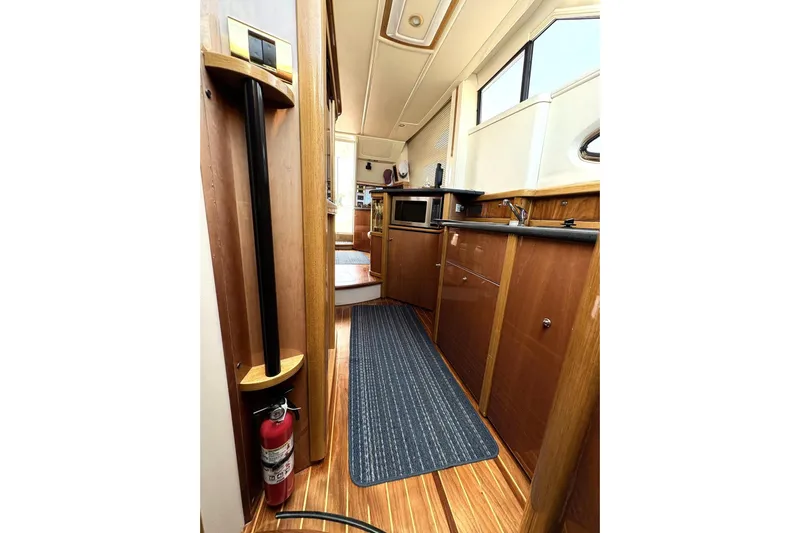 Pilot House Yacht Photos Pics 2003 Sealine F42/5 yacht interior with wood finish, kitchenette, and fire extinguisher.