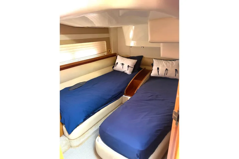 Pilot House Yacht Photos Pics Interior cabin of 2003 Sealine F42/5 yacht with twin beds and blue bedding.