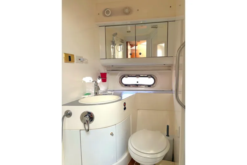 Pilot House Yacht Photos Pics Bathroom interior of 2003 Sealine F42/5 yacht with sink, toilet, and mirror cabinet.