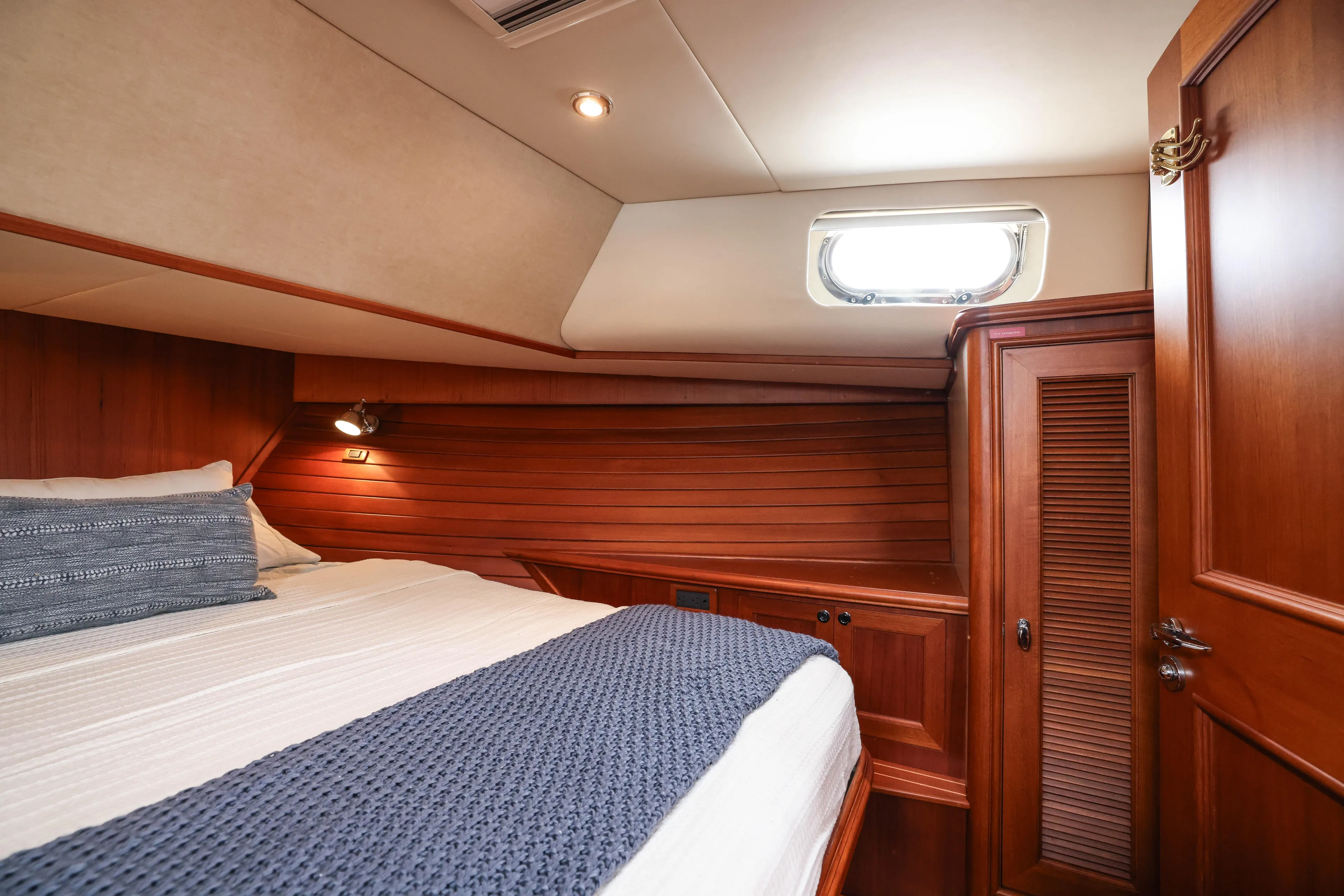 Aryeh Yacht Photos Pics Luxurious 2008 Grand Banks EASTBAY 39 SX cabin with wood paneling and cozy bedding.