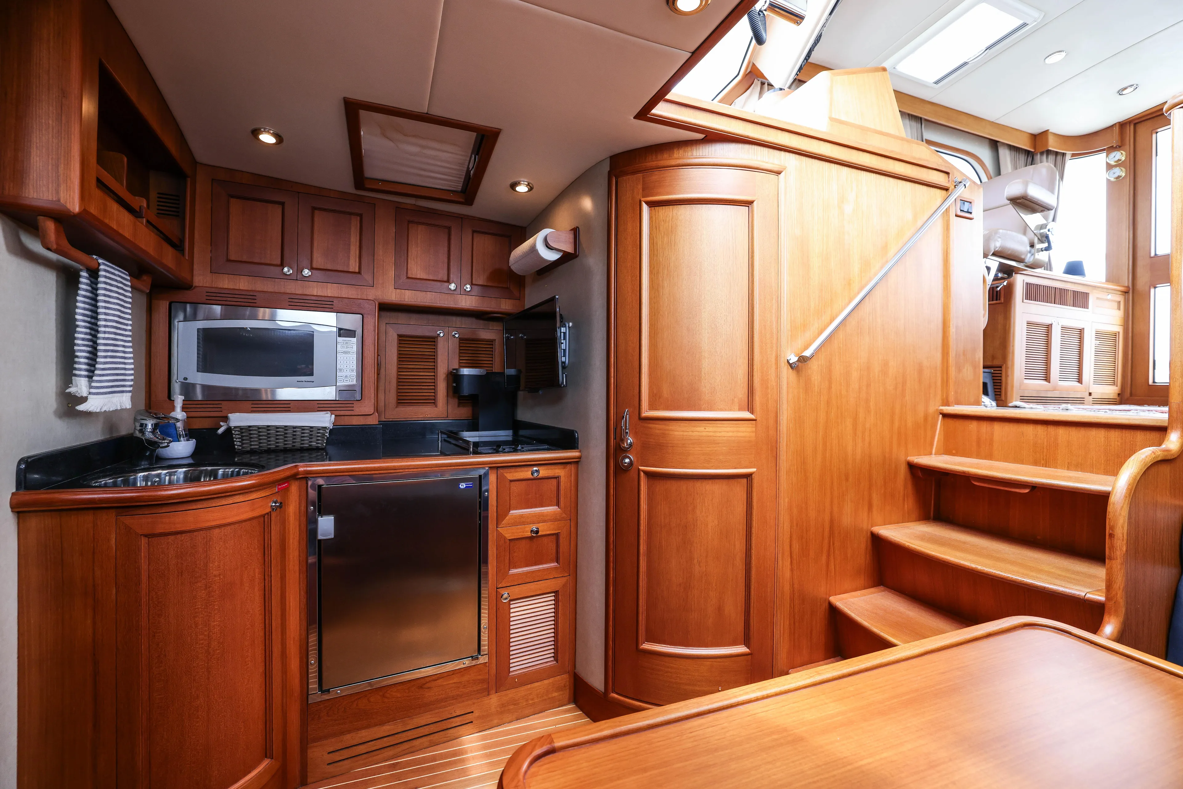 Aryeh Yacht Photos Pics Luxurious 2008 Grand Banks EASTBAY 39 SX yacht interior with wooden cabinetry and modern kitchen amenities.