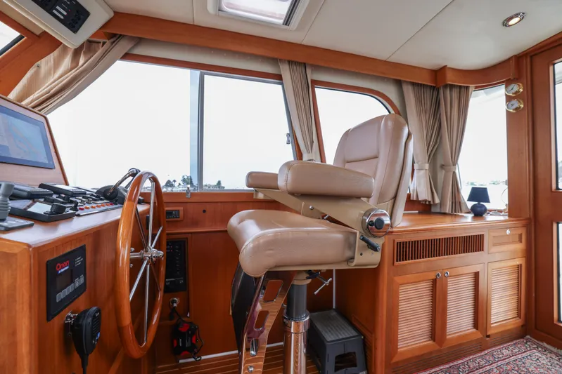 Aryeh Yacht Photos Pics Helm station of 2008 Grand Banks EASTBAY 39 SX with leather chair and wooden steering wheel.