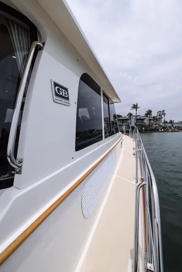 Aryeh Yacht Photos Pics 2008 Grand Banks EASTBAY 39 SX yacht side view, docked near waterfront homes.