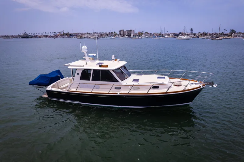Aryeh Yacht Photos Pics 2008 Grand Banks EASTBAY 39 SX yacht on calm water, cityscape in background.
