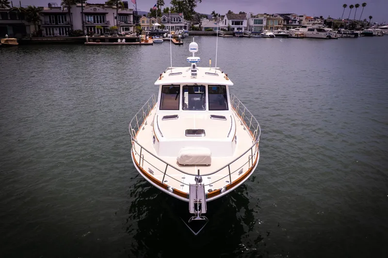 Aryeh Yacht Photos Pics 2008 Grand Banks EASTBAY 39 SX yacht on calm water, with waterfront homes in the background.