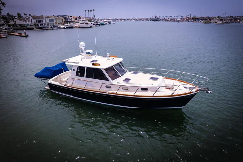 Aryeh Yacht Photos Pics 2008 Grand Banks EASTBAY 39 SX yacht on calm water, coastal homes in background.