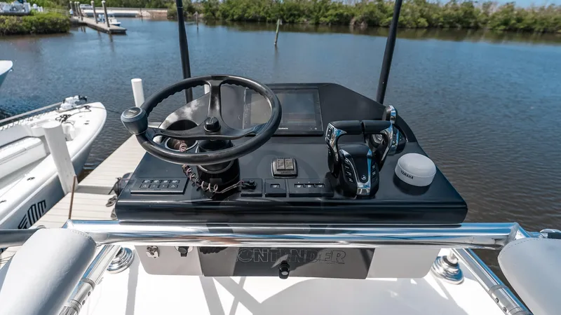  Yacht Photos Pics 2023 Contender 39 ST boat helm with steering wheel and controls, docked by the water.