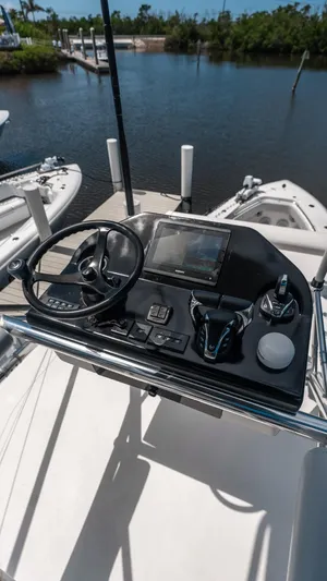  Yacht Photos Pics 2023 Contender 39 ST boat console with steering wheel and controls, docked by the water.