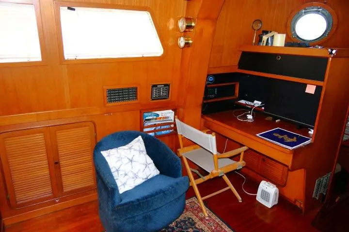 Avenir Yacht Photos Pics Cozy interior of 1982 Ta Shing Mason 63 yacht with seating and desk area.