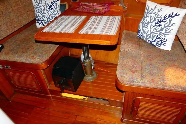 Avenir Yacht Photos Pics 1982 Ta Shing Mason 63 yacht interior with wooden dining area and decorative cushions.
