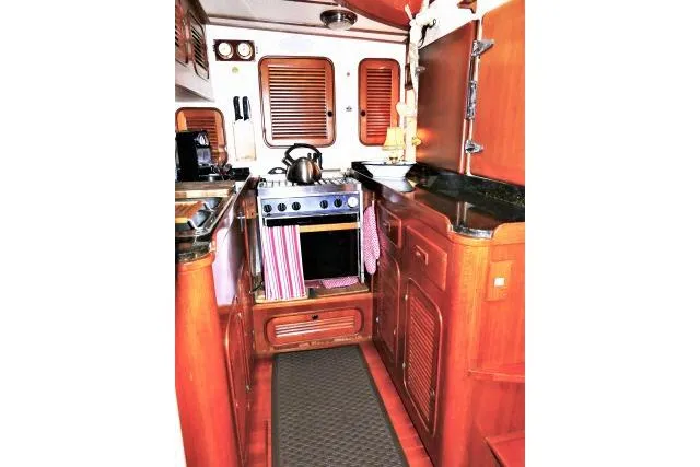 Avenir Yacht Photos Pics 1982 Ta Shing Mason 63 yacht kitchen with wooden cabinetry and compact stove.