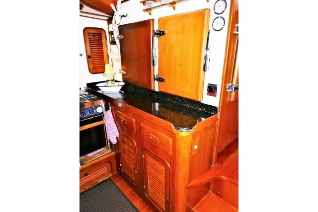 Avenir Yacht Photos Pics 1982 Ta Shing Mason 63 yacht interior with wooden cabinetry and black countertop.