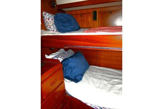Avenir Yacht Photos Pics Interior of 1982 Ta Shing Mason 63 yacht with wooden bunk beds and blue pillows.