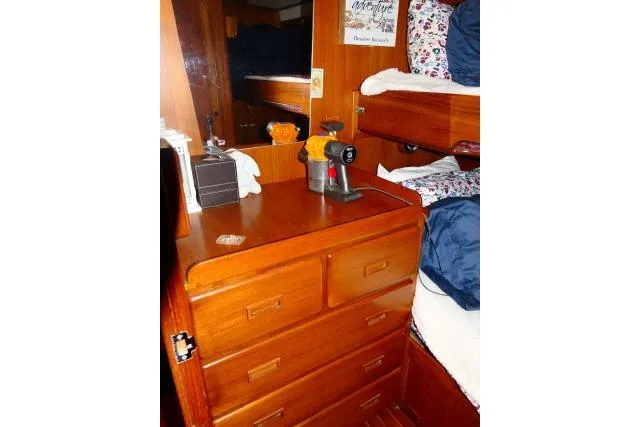 Avenir Yacht Photos Pics 1982 Ta Shing Mason 63 yacht interior with wooden drawers and cozy bedding.