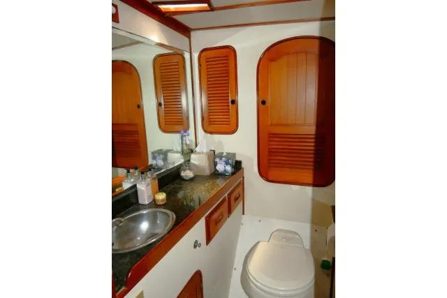 Avenir Yacht Photos Pics Bathroom interior of 1982 Ta Shing Mason 63 yacht with wooden cabinets and stainless steel sink.