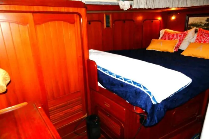 Avenir Yacht Photos Pics Luxurious wooden cabin interior of 1982 Ta Shing Mason 63 yacht with cozy bedding.