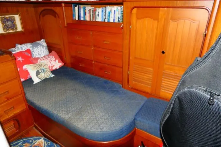 Avenir Yacht Photos Pics Cozy cabin interior of 1982 Ta Shing Mason 63 yacht with wooden furnishings and bedding.