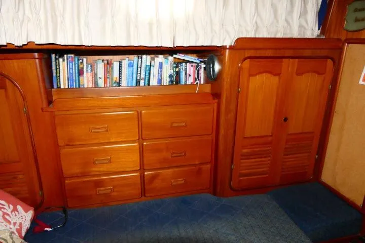 Avenir Yacht Photos Pics Interior of 1982 Ta Shing Mason 63 yacht with wooden cabinets and bookshelf.