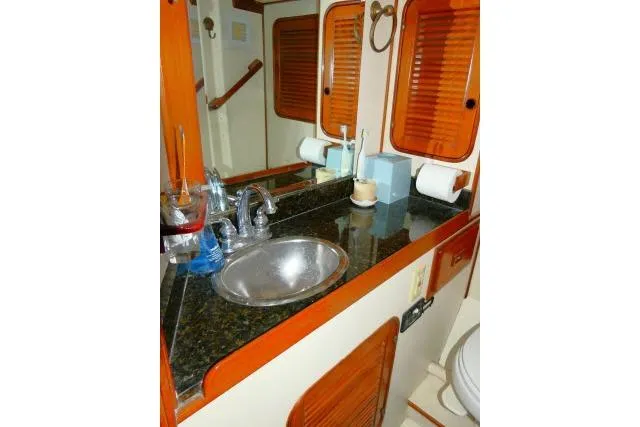 Avenir Yacht Photos Pics 1982 Ta Shing Mason 63 yacht bathroom with sink, mirror, and wooden accents.