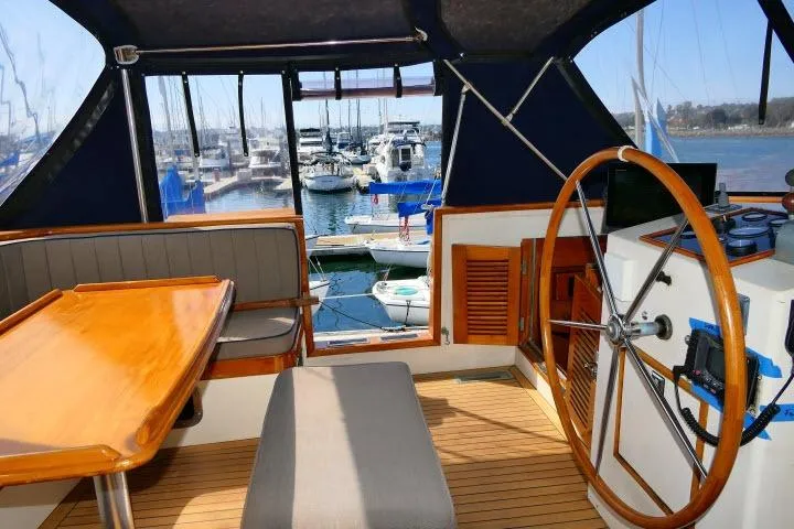 Avenir Yacht Photos Pics Interior view of 1982 Ta Shing Mason 63 yacht with wooden steering wheel and seating area.