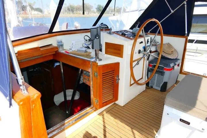 Avenir Yacht Photos Pics 1982 Ta Shing Mason 63 yacht cockpit with wooden accents and steering wheel.