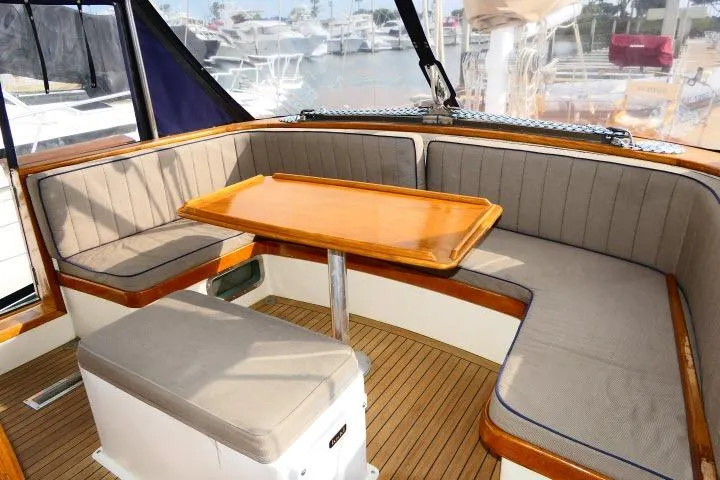 Avenir Yacht Photos Pics Interior of 1982 Ta Shing Mason 63 yacht with cushioned seating and wooden table.