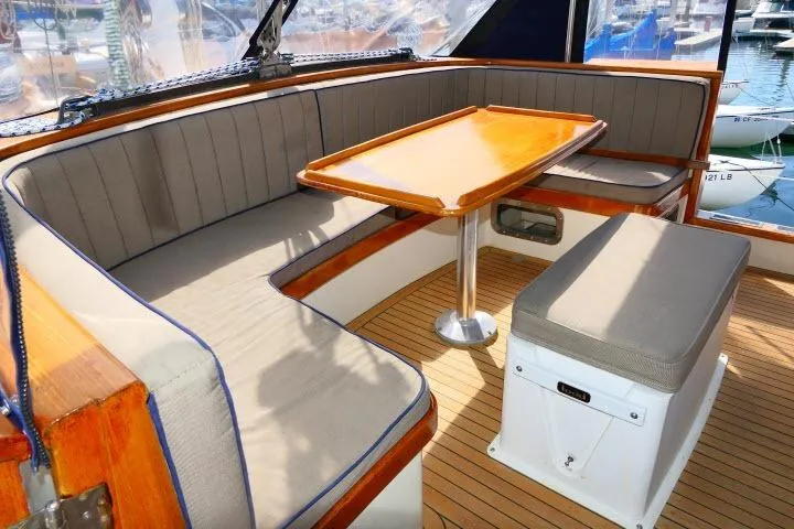 Avenir Yacht Photos Pics Elegant 1982 Ta Shing Mason 63 yacht interior with cushioned seating and wooden table.