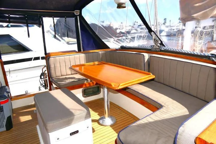 Avenir Yacht Photos Pics Interior of 1982 Ta Shing Mason 63 yacht with cushioned seating and wooden table.