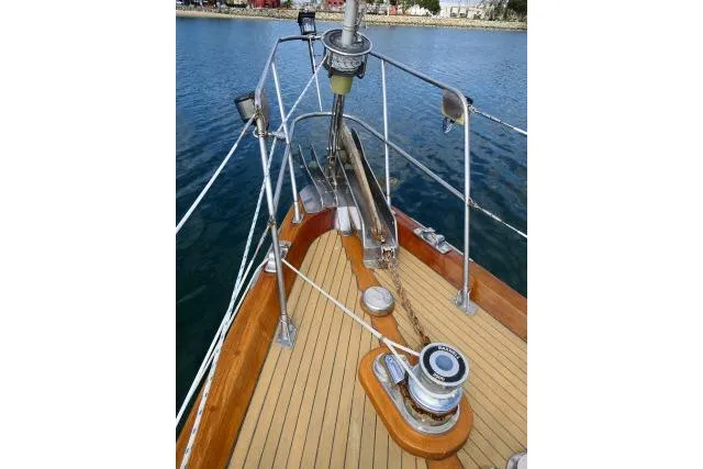 Avenir Yacht Photos Pics 1982 Ta Shing Mason 63 yacht deck with winch and anchor, docked on calm water.
