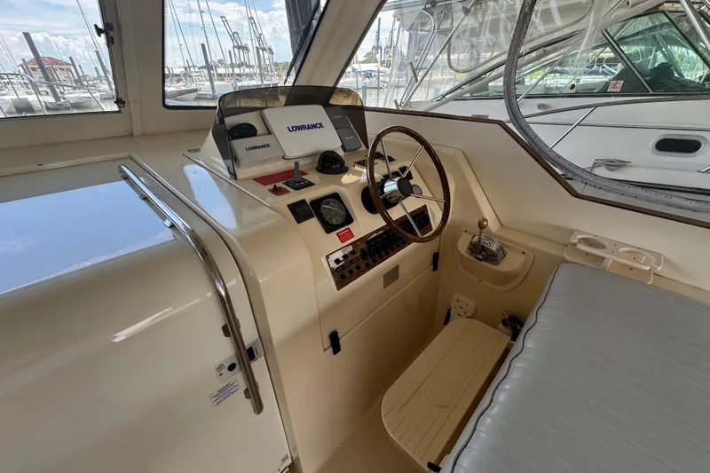  Yacht Photos Pics 2003 Mainship Pilot 34 helm with steering wheel, navigation equipment, and marina view.