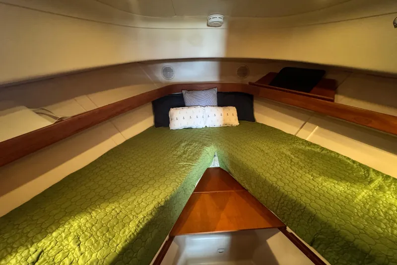  Yacht Photos Pics Cozy cabin interior of 2003 Mainship Pilot 34 with green bedding and wooden accents.