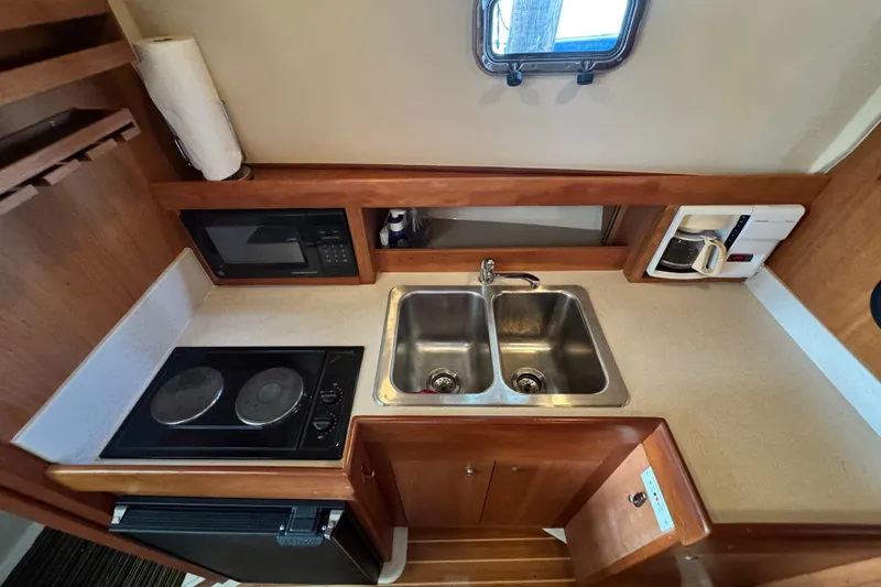  Yacht Photos Pics 2003 Mainship Pilot 34 galley with dual sink, stove, microwave, and coffee maker.