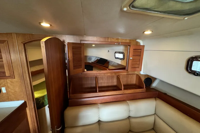  Yacht Photos Pics Interior of 2003 Mainship Pilot 34, featuring wood cabinetry and cozy seating area.