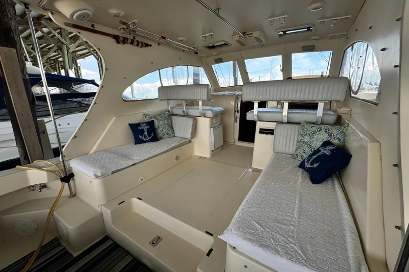  Yacht Photos Pics 2003 Mainship Pilot 34 interior with cushioned seating and nautical-themed pillows.