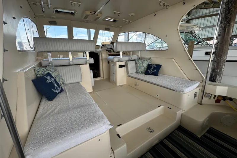  Yacht Photos Pics 2003 Mainship Pilot 34 interior with cushioned seating and nautical-themed pillows.