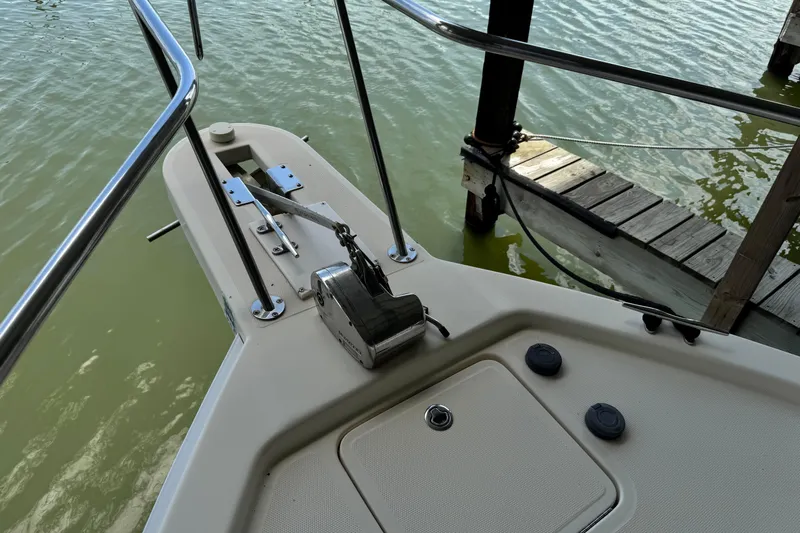  Yacht Photos Pics 2003 Mainship Pilot 34 boat deck with anchor system and railing by the water.