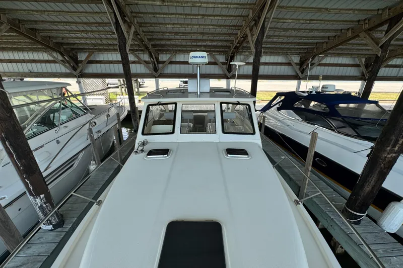  Yacht Photos Pics 2003 Mainship Pilot 34 docked under a covered marina, surrounded by other boats.