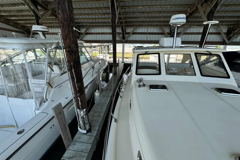  Yacht Photos Pics 2003 Mainship Pilot 34 docked under a covered marina, showcasing its sleek design.