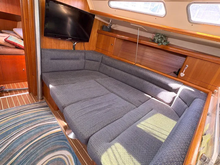 Bylgja Yacht Photos Pics Interior of 2005 Hunter 38 sailboat with cozy seating and mounted TV.