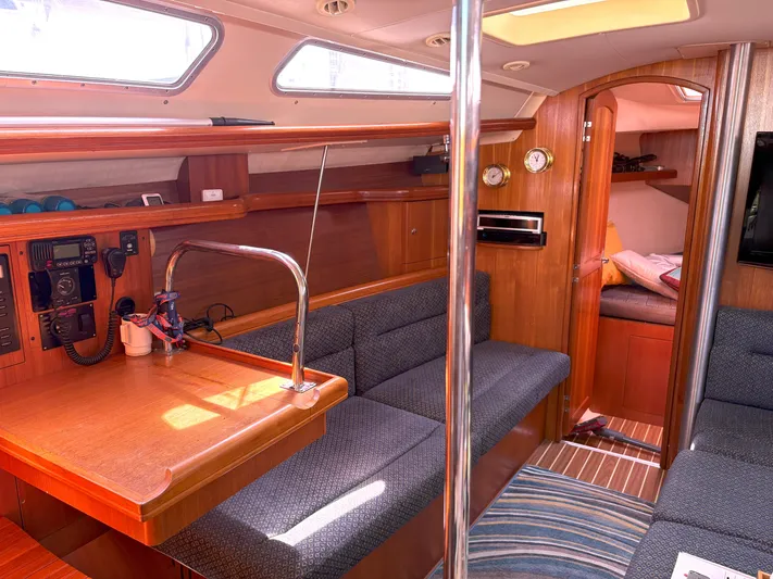 Bylgja Yacht Photos Pics Interior of a 2005 Hunter 38 sailboat with cozy seating and wooden finishes.