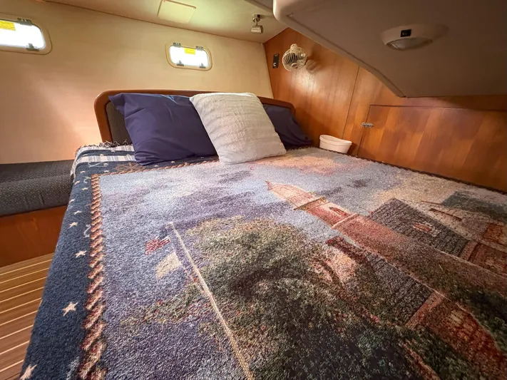 Bylgja Yacht Photos Pics Cozy cabin interior of 2005 Hunter 38 sailboat with decorative bedding and wooden accents.
