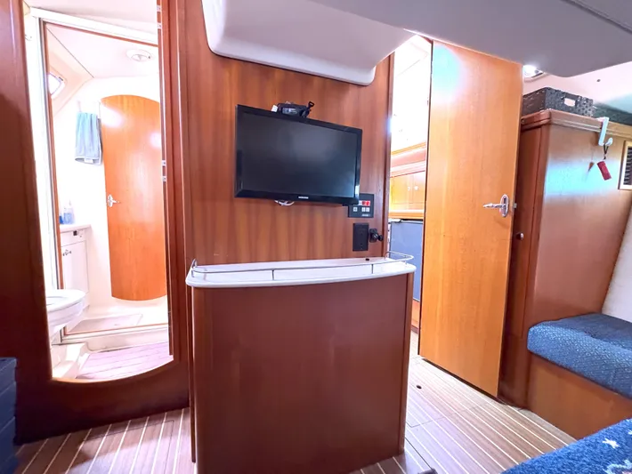 Bylgja Yacht Photos Pics Interior of 2005 Hunter 38 yacht with TV, wooden cabinetry, and bathroom view.